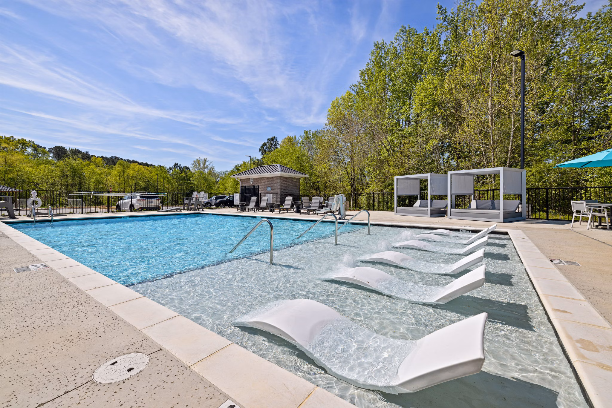 Sparkling pool at Encore at Heritage Apartments with modern lounge chairs, perfect for leisure and relaxation in a luxury setting