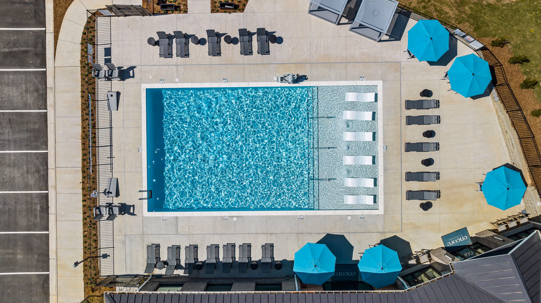 Refreshing poolside retreat at Encore at Heritage Apartments with lush surroundings and lounge chairs perfect for relaxation