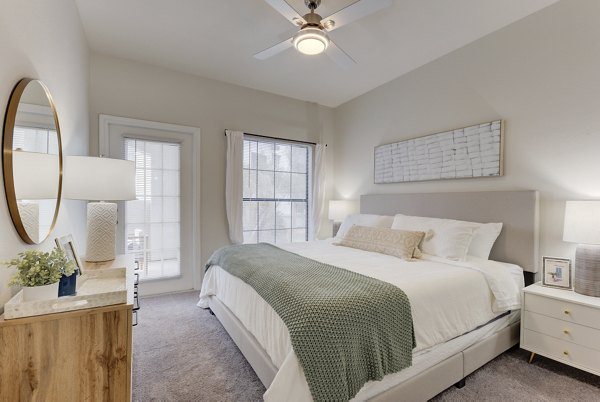 Cozy bedroom with modern furnishings at Sendero Ridge Apartments in a luxurious Greystar community setting
