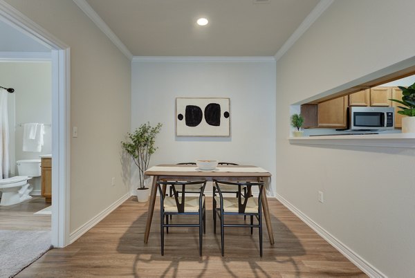 Modern dining room with elegant lighting and art in Sendero Ridge Apartments