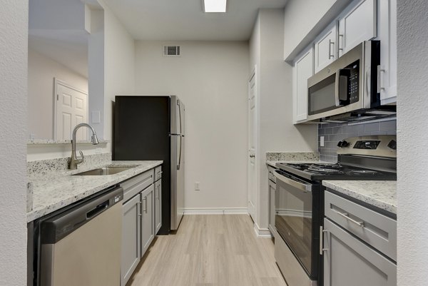 Modern kitchen with stainless steel appliances in Sendero Ridge Apartments
