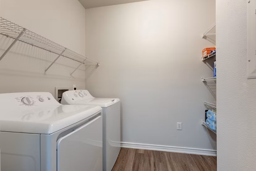 Laundry room featuring modern appliances at Sendero Ridge Apartments