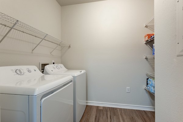 Laundry room featuring modern appliances at Sendero Ridge Apartments