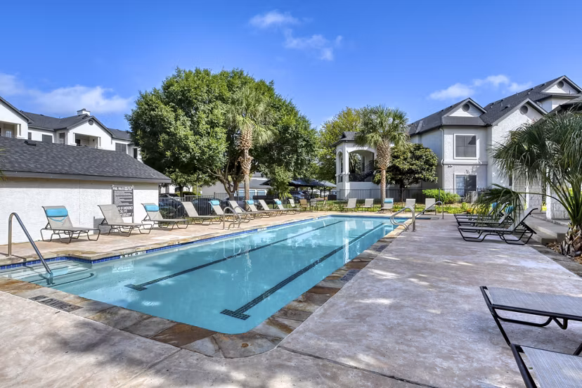 Outdoor pool with lounge chairs at Sendero Ridge Apartments offering luxury amenities