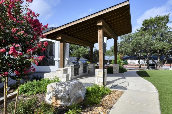 Recreational area featuring landscaped gardens and picnic tables at Sendero Ridge Apartments