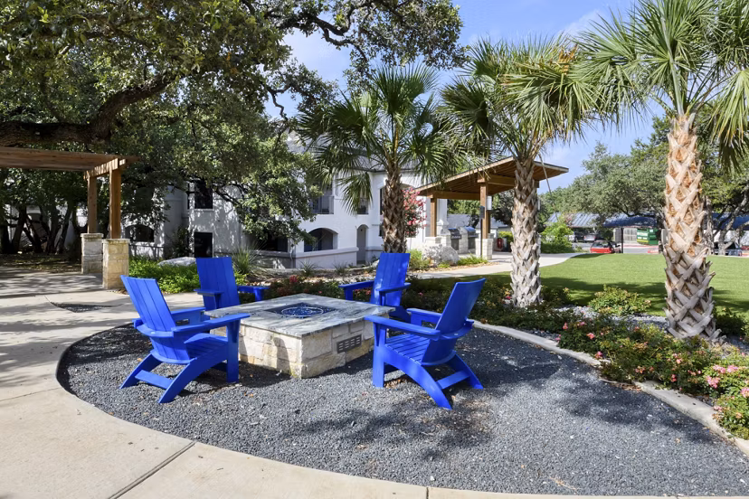 Outdoor recreational area with lush greenery at Sendero Ridge Apartments, offering a serene environment for relaxation and leisure activities