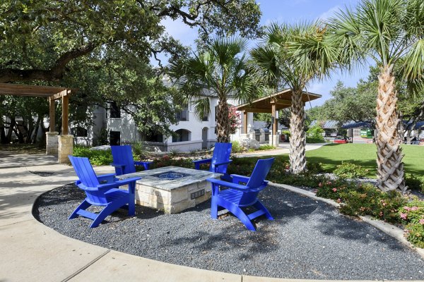Outdoor recreational area with lush greenery at Sendero Ridge Apartments, offering a serene environment for relaxation and leisure activities