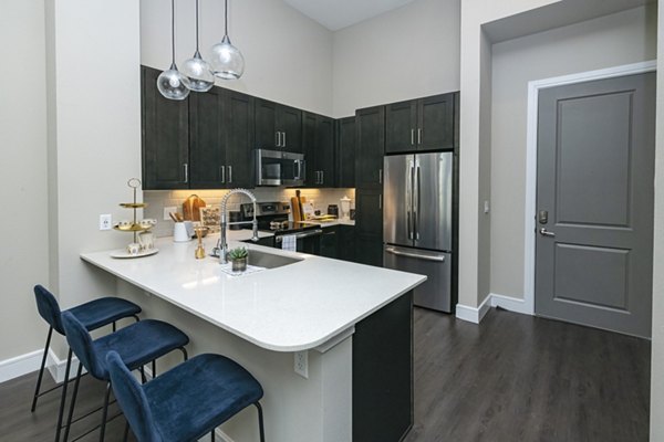 Modern kitchen with stainless steel appliances and granite countertops at Canal 1535 Apartments