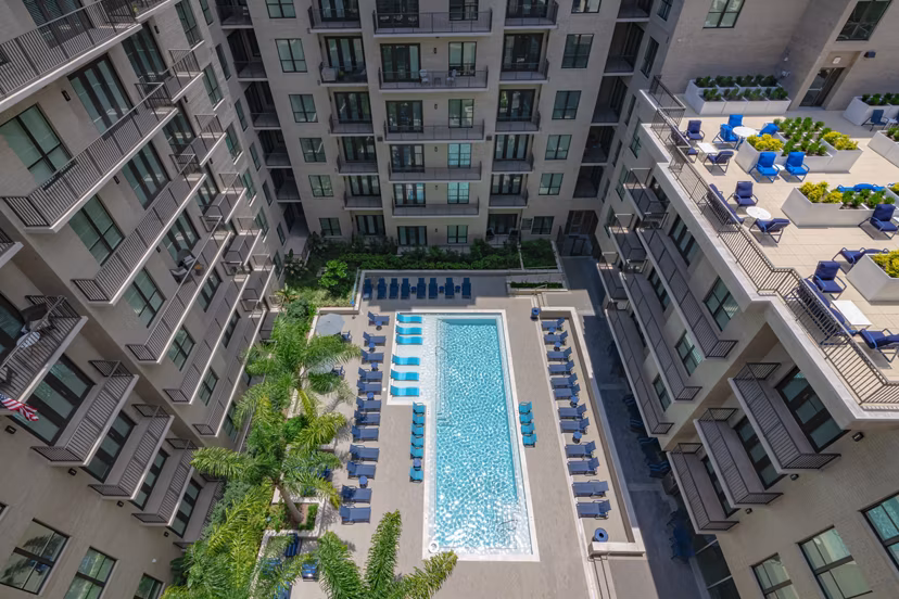 Sunlit poolside lounging area at Canal 1535 Apartments