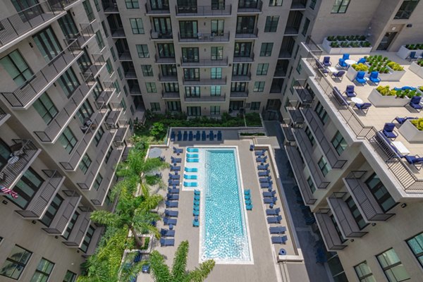 Sunlit poolside lounging area at Canal 1535 Apartments