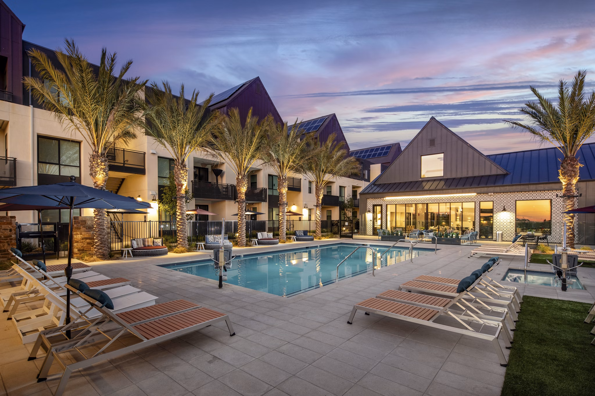 Silo Apartments: Luxurious outdoor pool with sun loungers and lush landscaping