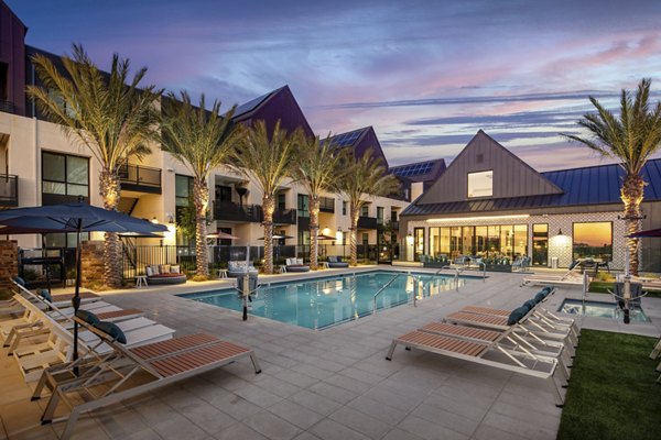 Silo Apartments: Luxurious outdoor pool with sun loungers and lush landscaping