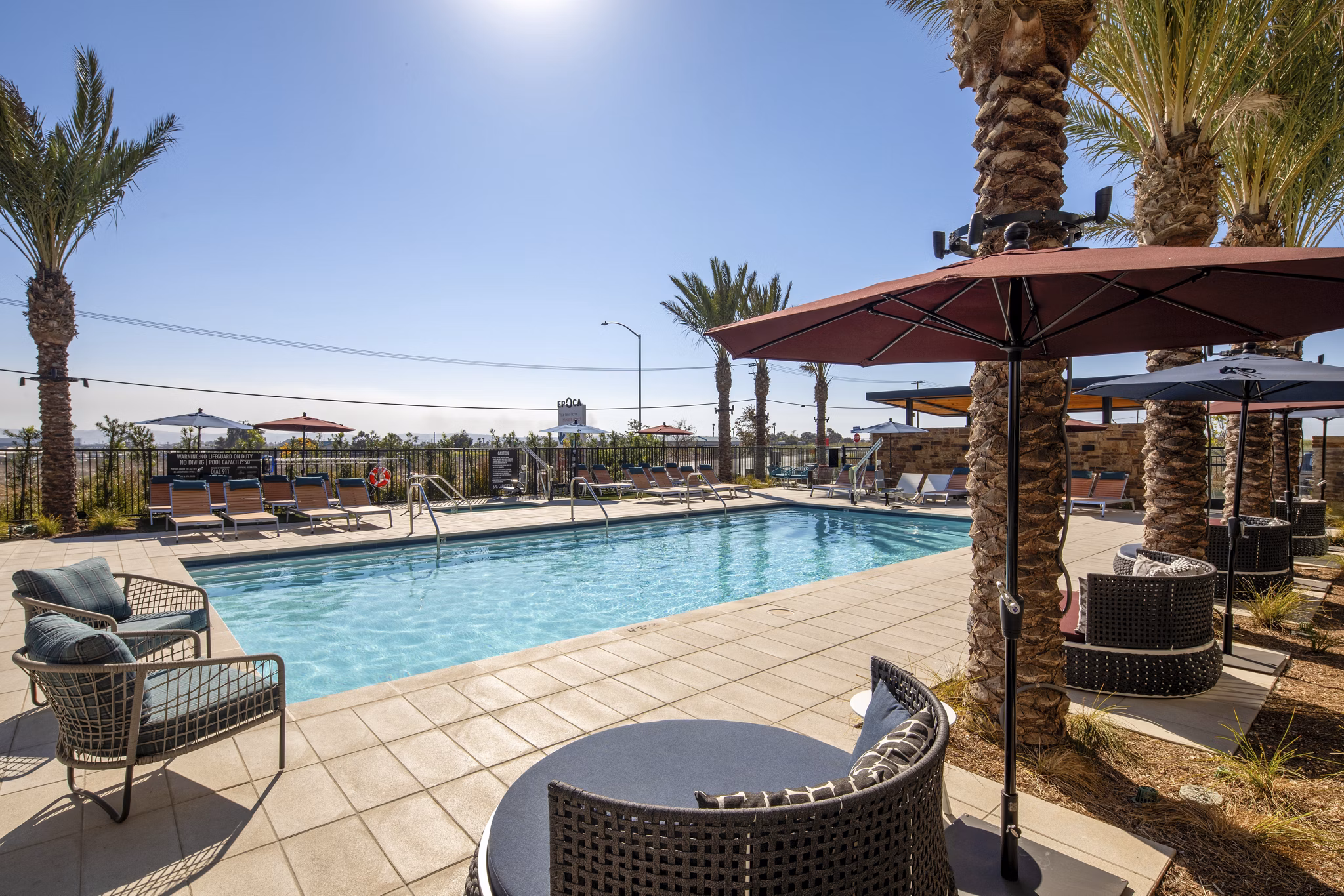 Silo Apartments: Stylish pool area with lounge chairs and umbrellas offering relaxation and luxury at Greystar's Silo Apartments