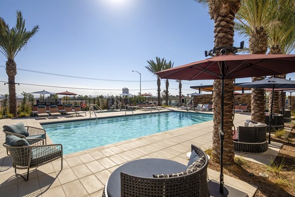 Silo Apartments: Stylish pool area with lounge chairs and umbrellas offering relaxation and luxury at Greystar's Silo Apartments