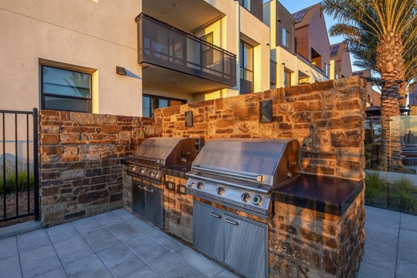 Outdoor communal grill area at Silo Apartments with modern facilities and seating, perfect for gatherings and barbecues