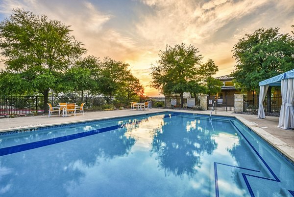 Resort-style pool at Ventura Ridge Apartments with sunloungers and lush landscaping