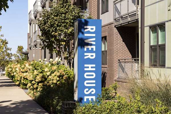 Elegant signage at River House Apartments highlighting luxury living near urban conveniences