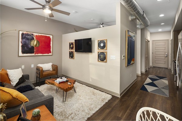 Elegant living room with modern furnishings and large windows at River House Apartments