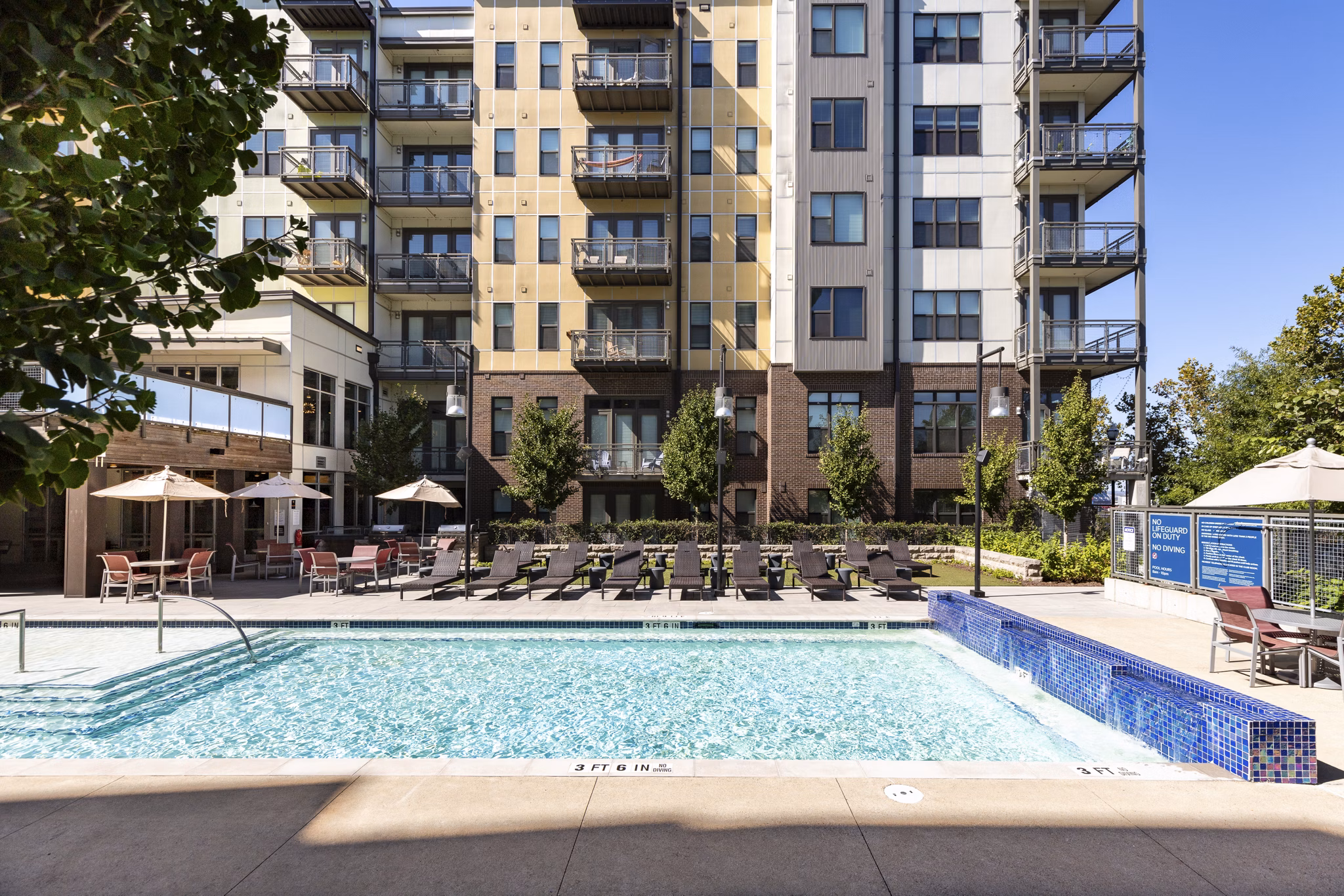 Resort-style pool with lounge chairs at River House Apartments, offering luxury amenities for relaxation and recreation