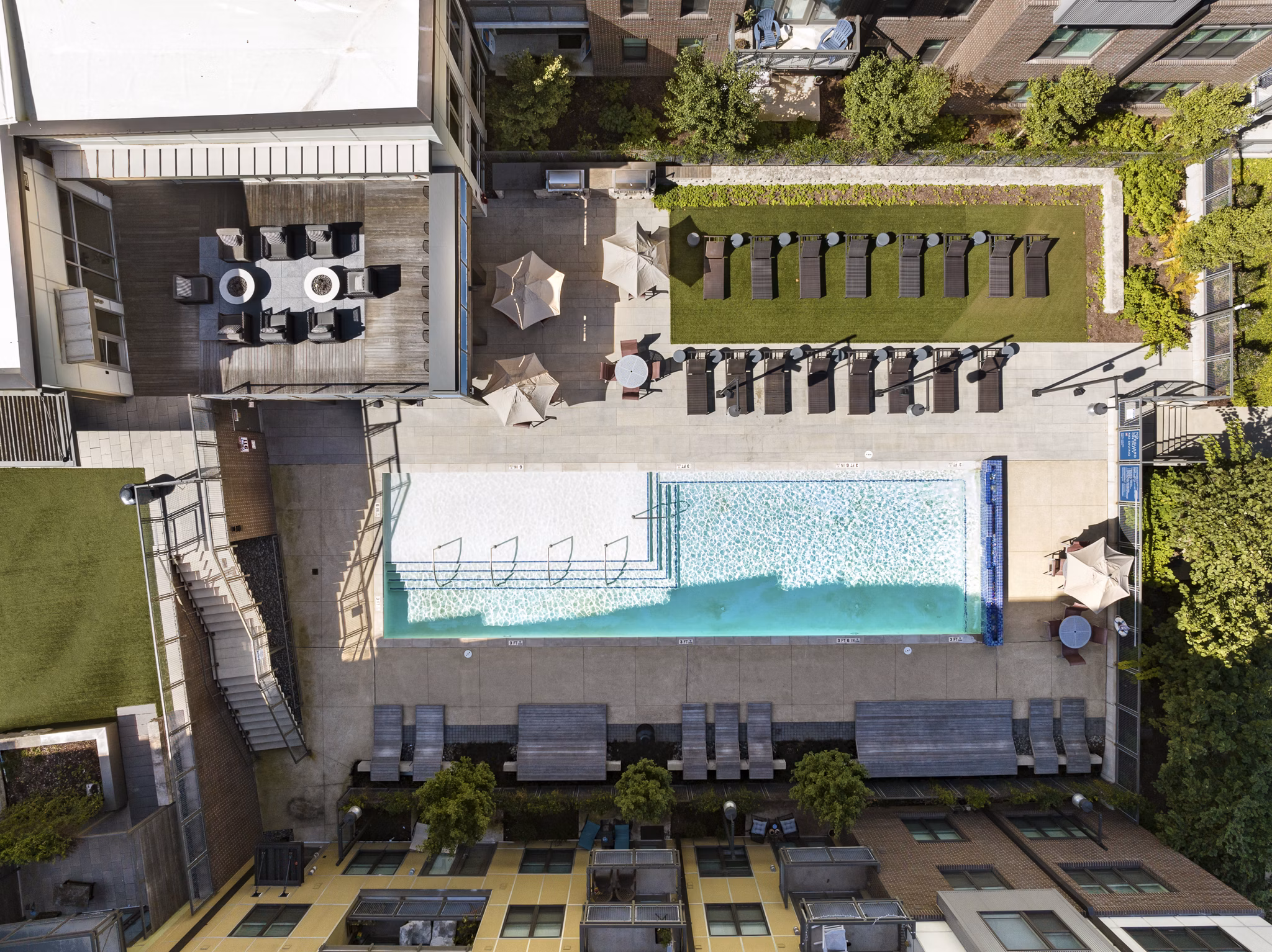 Aerial view of luxury apartments featuring a swimming pool and outdoor lounge areas