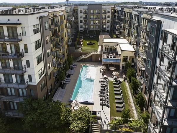 Luxury apartments with a central courtyard featuring a swimming pool and lounge chairs