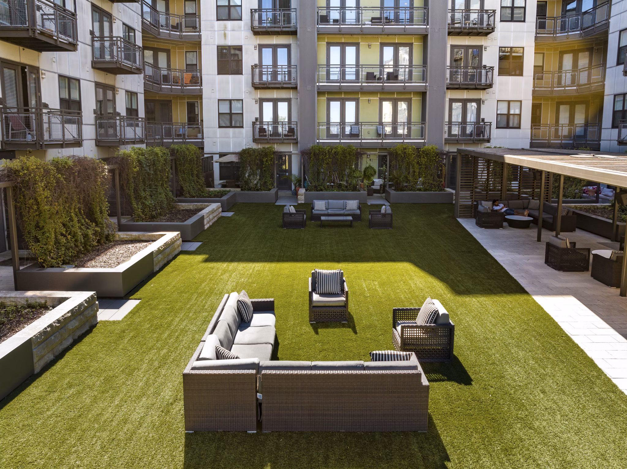Outdoor courtyard with artificial grass and seating arrangements at luxury apartments