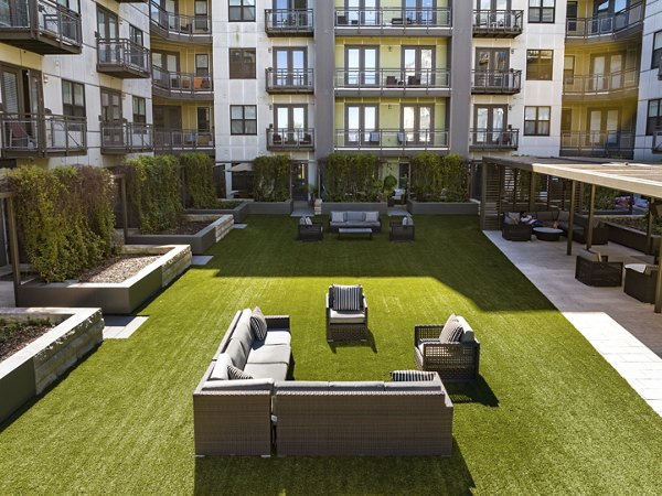 Outdoor courtyard with artificial grass and seating arrangements at luxury apartments