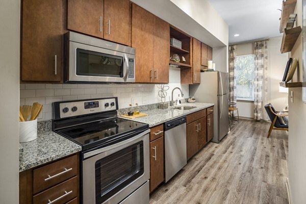 Modern kitchen with stainless steel appliances at Terra House Apartments, offering luxury living and contemporary design