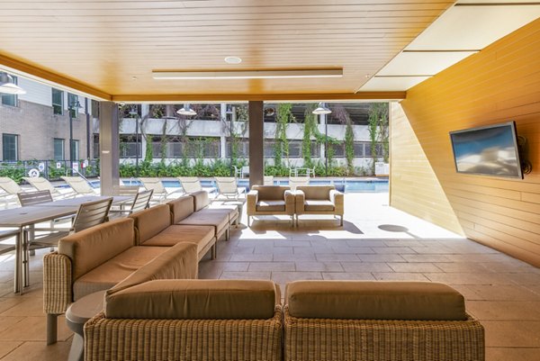 Poolside lounge area at Terra House Apartments offering luxury relaxation with seating around a sparkling pool