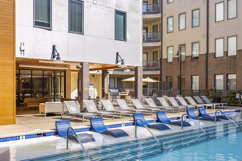 Luxurious poolside view at Terra House Apartments, featuring lounge chairs and modern design Enjoy summer relaxation at this premium location