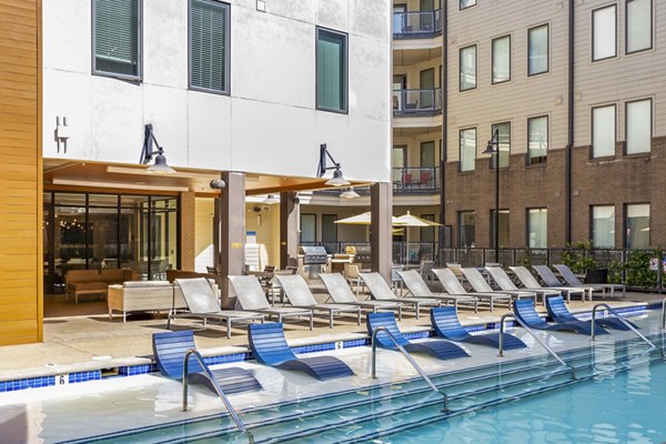 Luxurious poolside view at Terra House Apartments, featuring lounge chairs and modern design Enjoy summer relaxation at this premium location