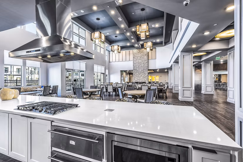 Clubhouse kitchen with modern appliances at Larkspur at Creekside Apartments, featuring sleek countertops and ample storage options for residents