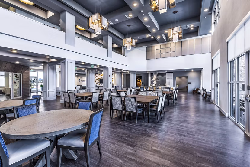Clubhouse dining area with elegant seating and modern lighting at Larkspur at Creekside Apartments, offering a luxurious community experience