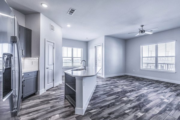 Larkspur at Creekside Apartments: Modern kitchen with stainless steel appliances and granite countertops