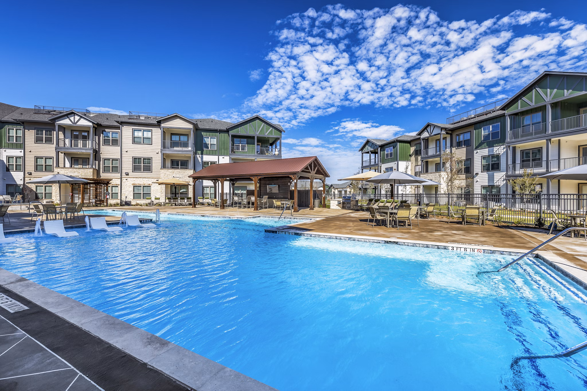 Rooftop pool with sun loungers at Larkspur at Creekside Apartments, offering relaxation and leisure amidst scenic views