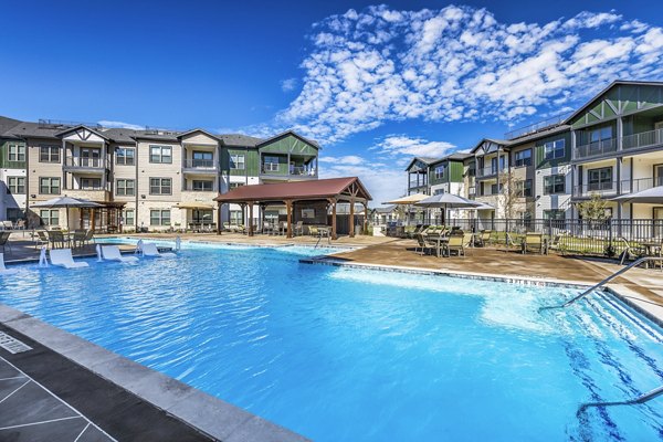 Rooftop pool with sun loungers at Larkspur at Creekside Apartments, offering relaxation and leisure amidst scenic views