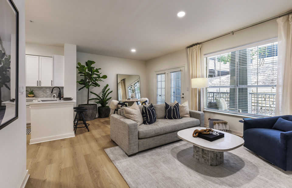 Spacious living room with modern decor and large windows in The Lola Apartments
