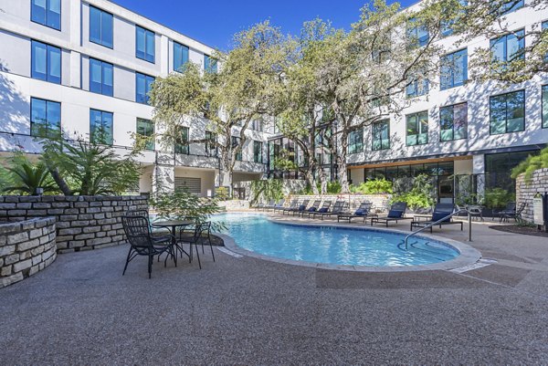 Rooftop pool with lounge chairs at The Lola Apartments offering luxury relaxation