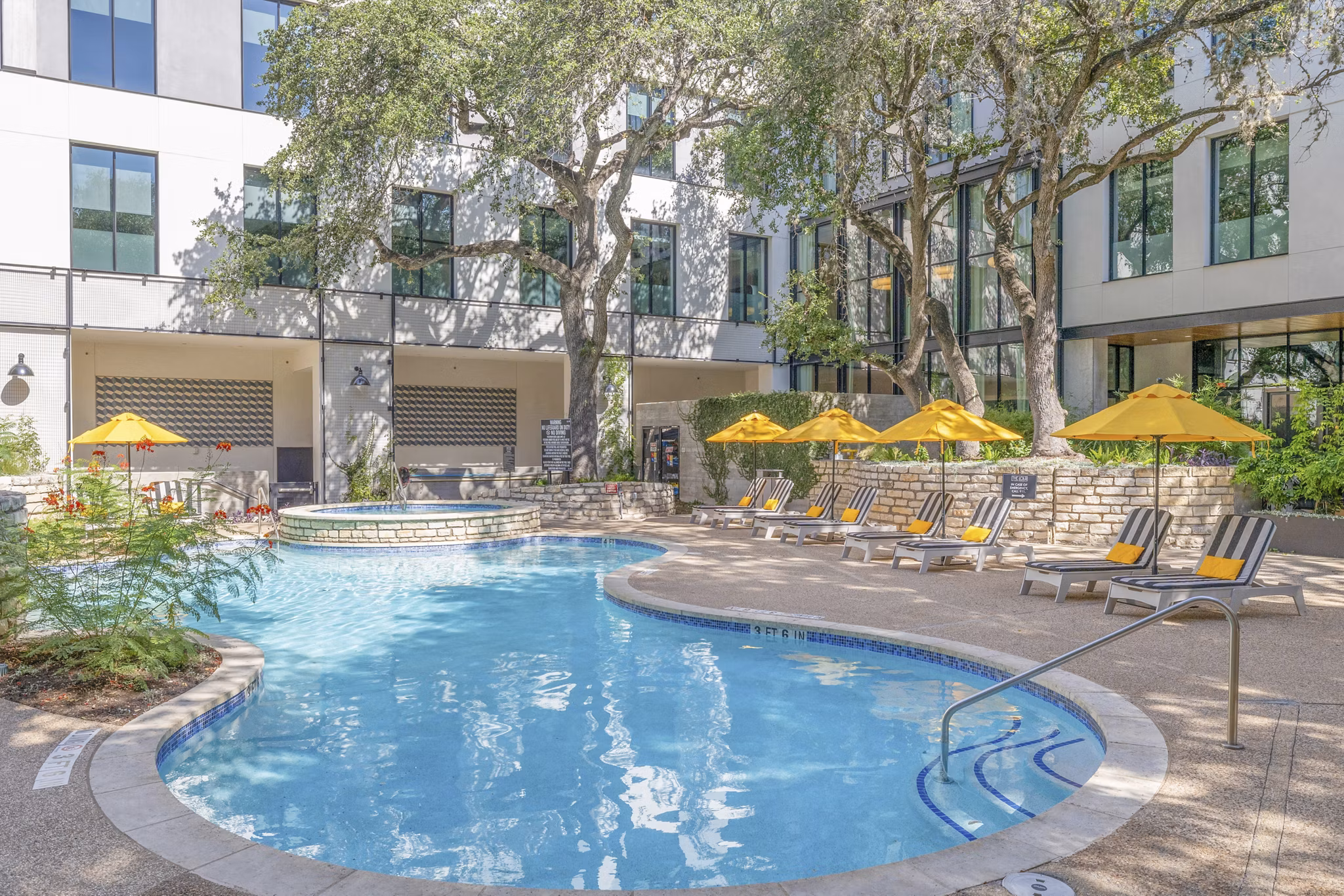 Sparkling outdoor pool at The Lola Apartments, luxury property with resort-style amenities