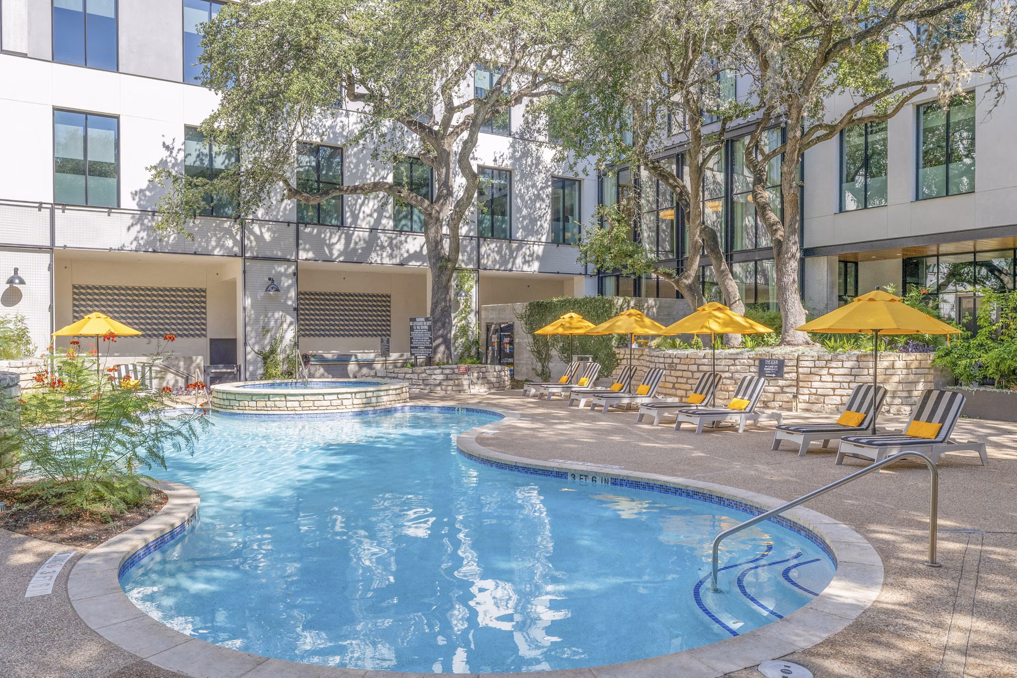 Sparkling outdoor pool at The Lola Apartments, luxury property with resort-style amenities