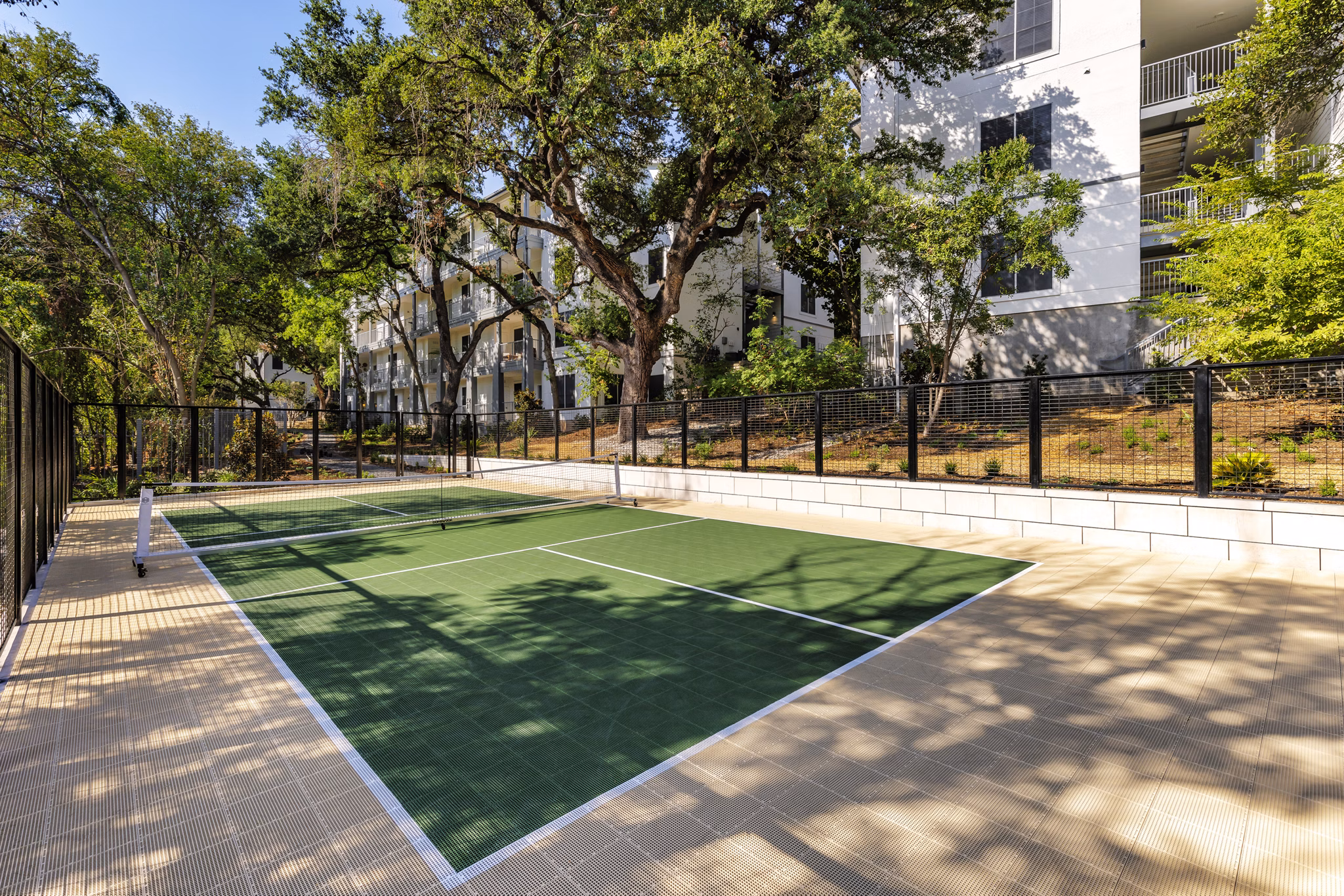 Sport court for residents at The Lola Apartments offering recreational space for basketball and tennis enthusiasts