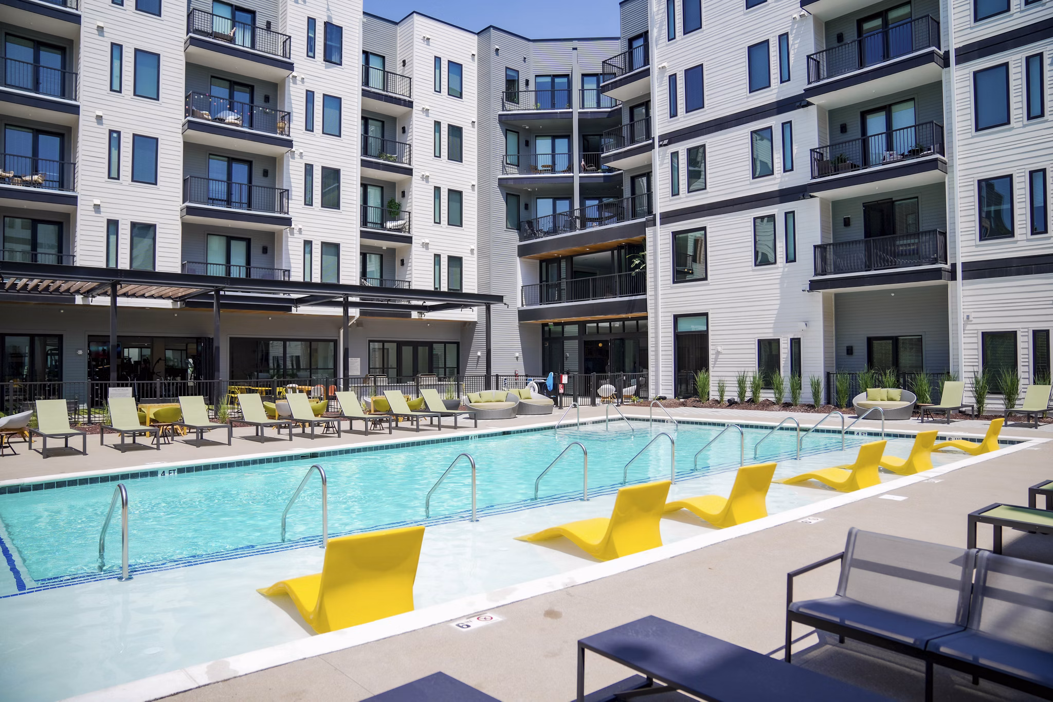 Chic outdoor pool area with lounge seating at Standard Assembly Apartments, offering luxury living amenities