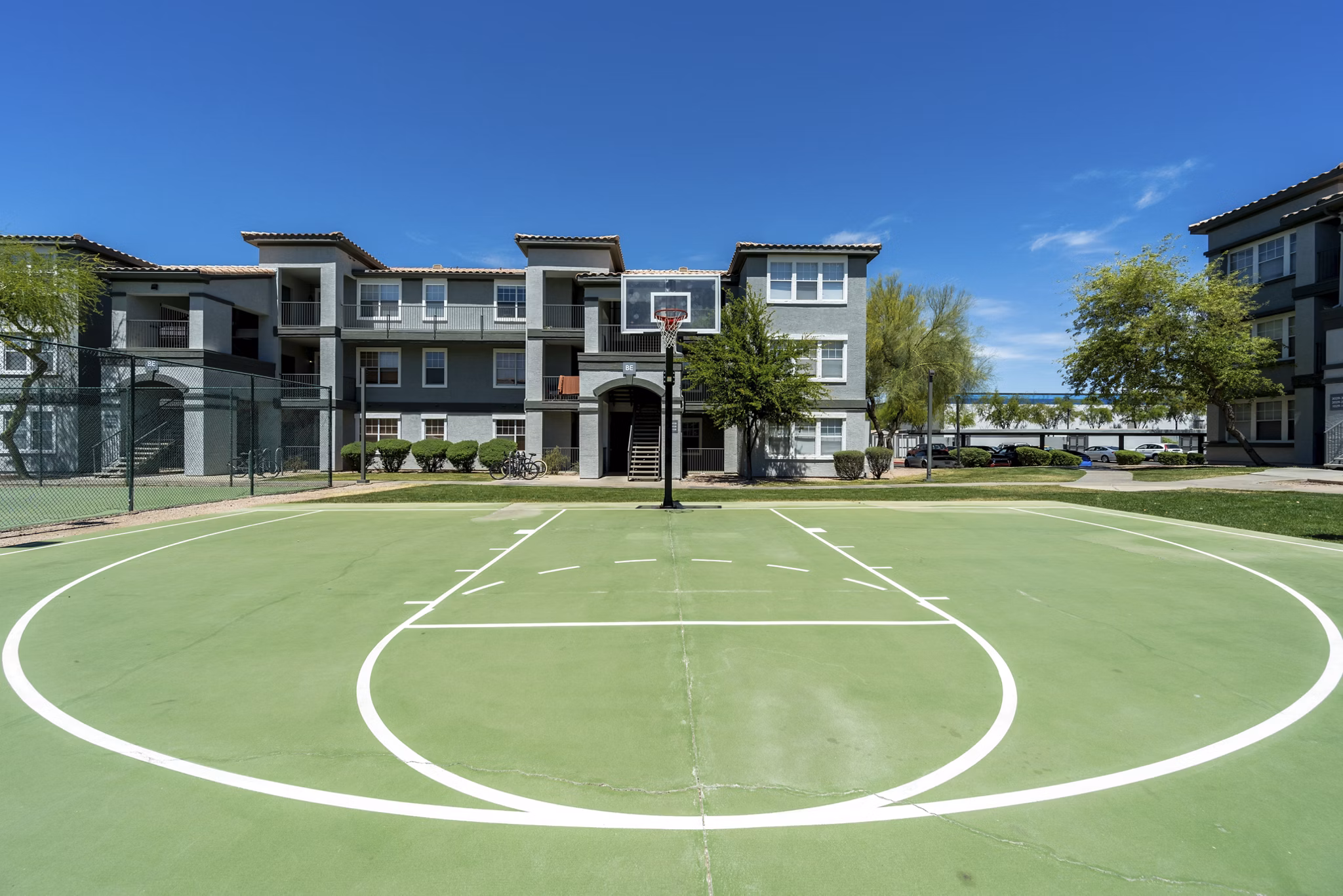 Outdoor sport court at Gateway at Tempe Apartments featuring basketball and tennis facilities for active recreation
