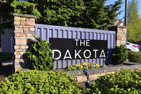 Signage welcoming residents at The Dakota Apartments, known for luxury living and modern design in the heart of the city