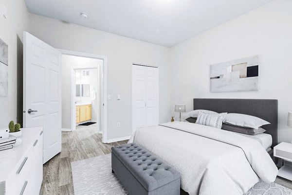 Spacious bedroom with modern decor and large windows at The Dakota Apartments in downtown