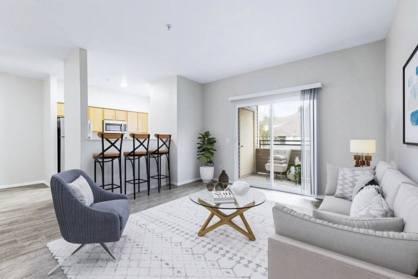 Cozy living room featuring stylish furniture and large windows at The Dakota Apartments