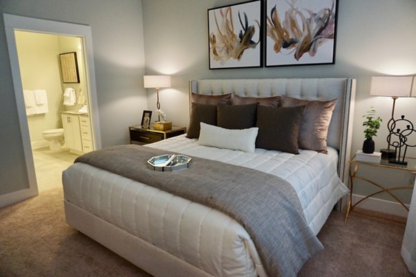 Bedroom featuring modern decor and plush bedding in The Peak at Nichols Plaza Apartments, a Greystar luxury community