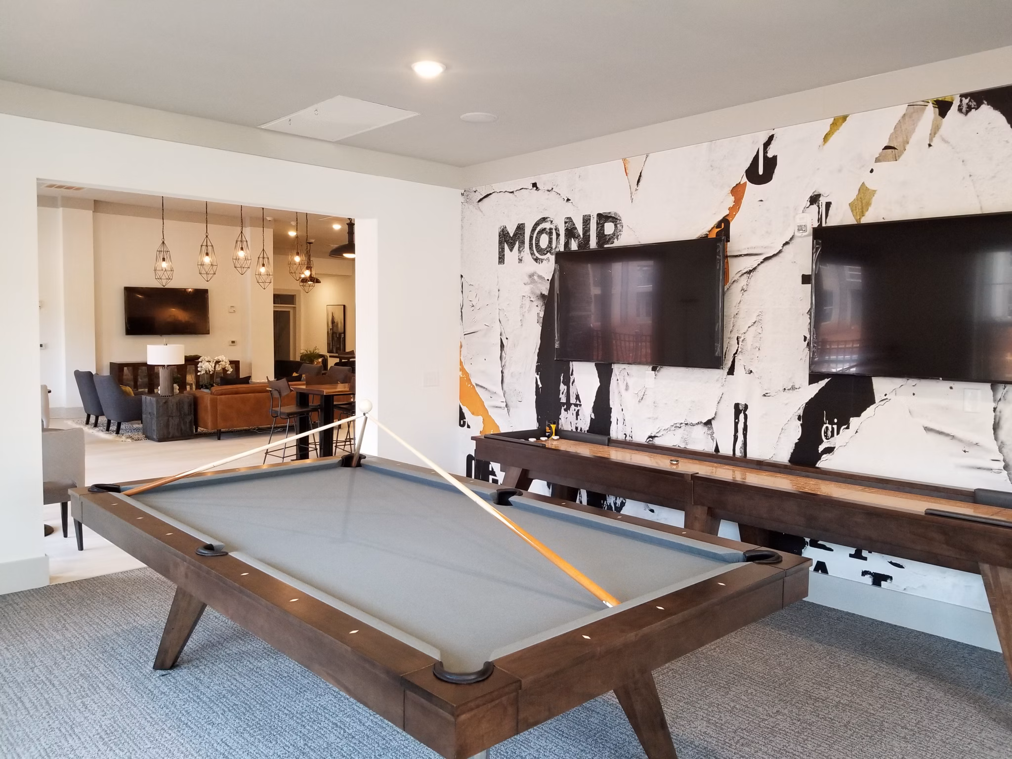 Clubhouse featuring modern lounge seating and fireplace at The Peak at Nichols Plaza Apartments