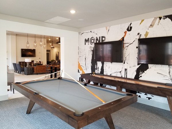 Clubhouse featuring modern lounge seating and fireplace at The Peak at Nichols Plaza Apartments