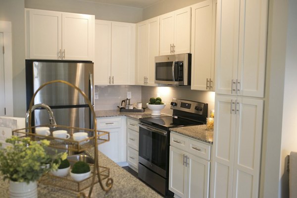 Modern kitchen with stainless steel appliances in The Peak at Nichols Plaza Apartments